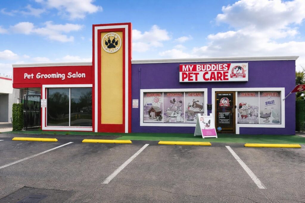 Brightly colored pet grooming and care facility featuring "My Buddies Pet Care" signage, with services for grooming, boarding, and training displayed in window graphics.